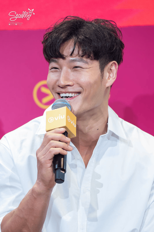 A man in a white shirt smiles while holding a microphone with a 'Viu' logo during a press event.